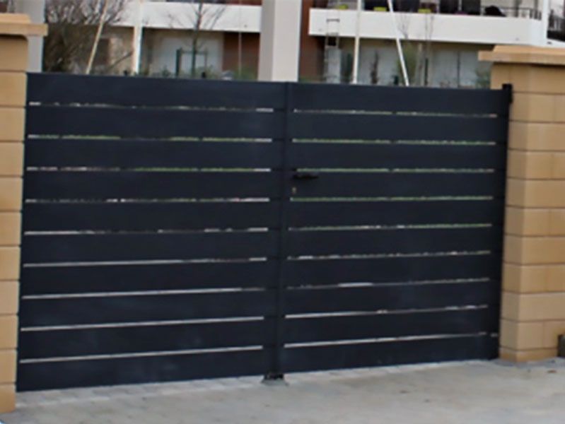 Installation d’un portail en aluminium noir avec lames horizontales, monté sur piliers en béton – Pose de portails par AK Rénovation dans le Pays de Gex
